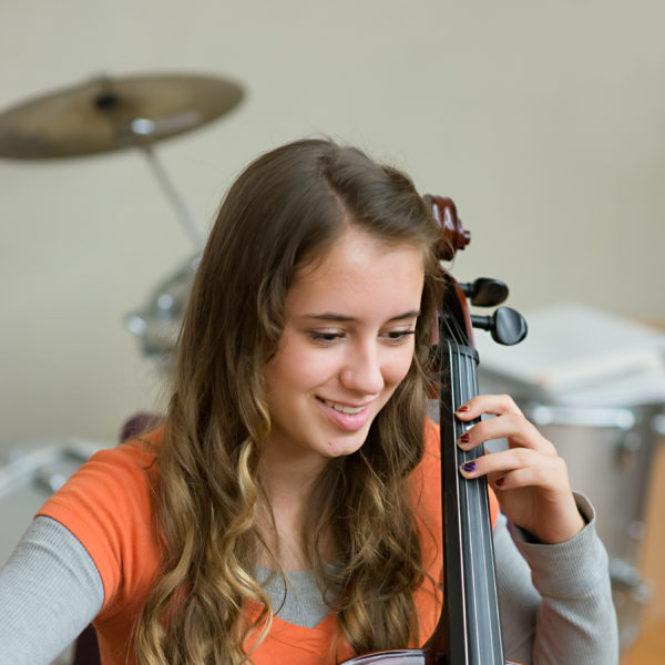 Student playing a stringed instrument